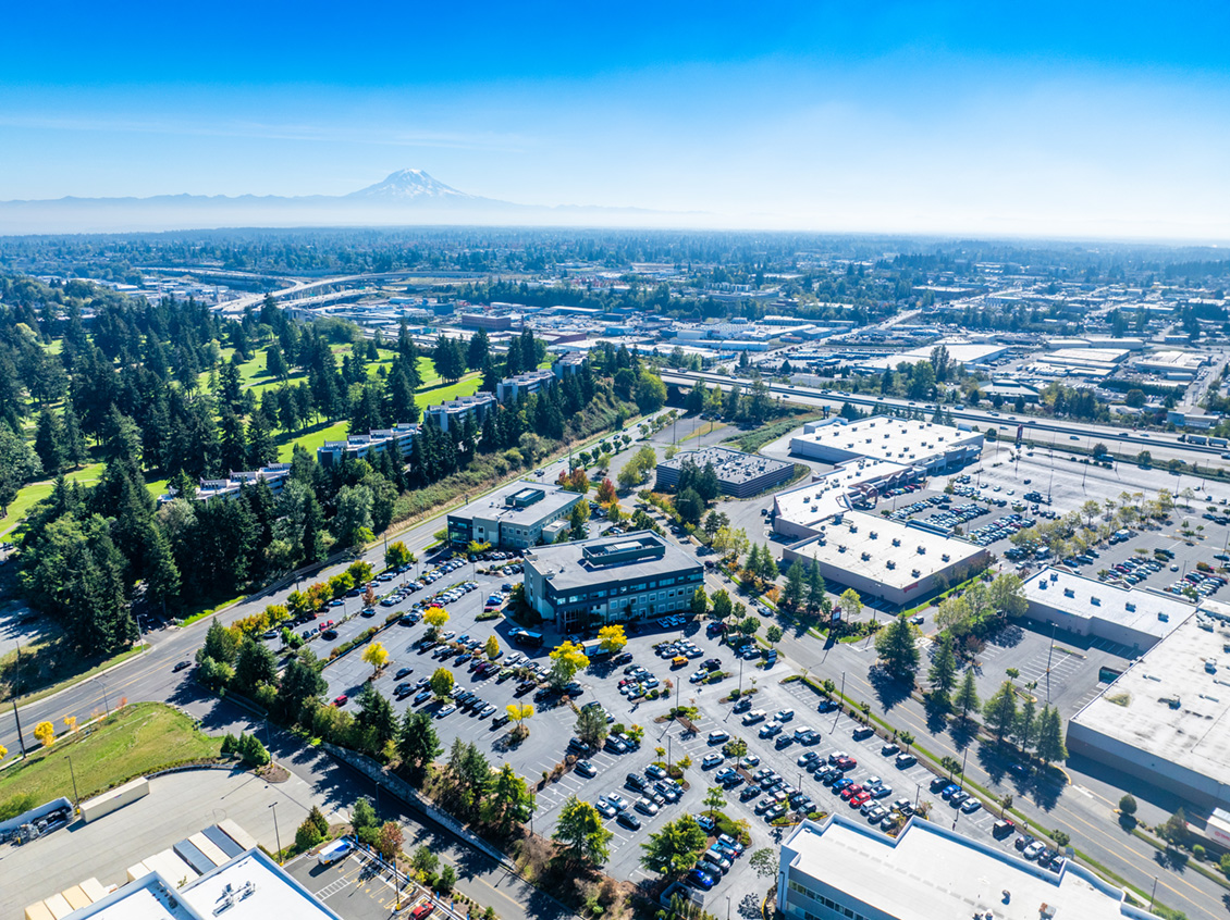 Aerial shot of Allenmore Buildings on a clear day with blue sky and Mt. Rainier in the distance.